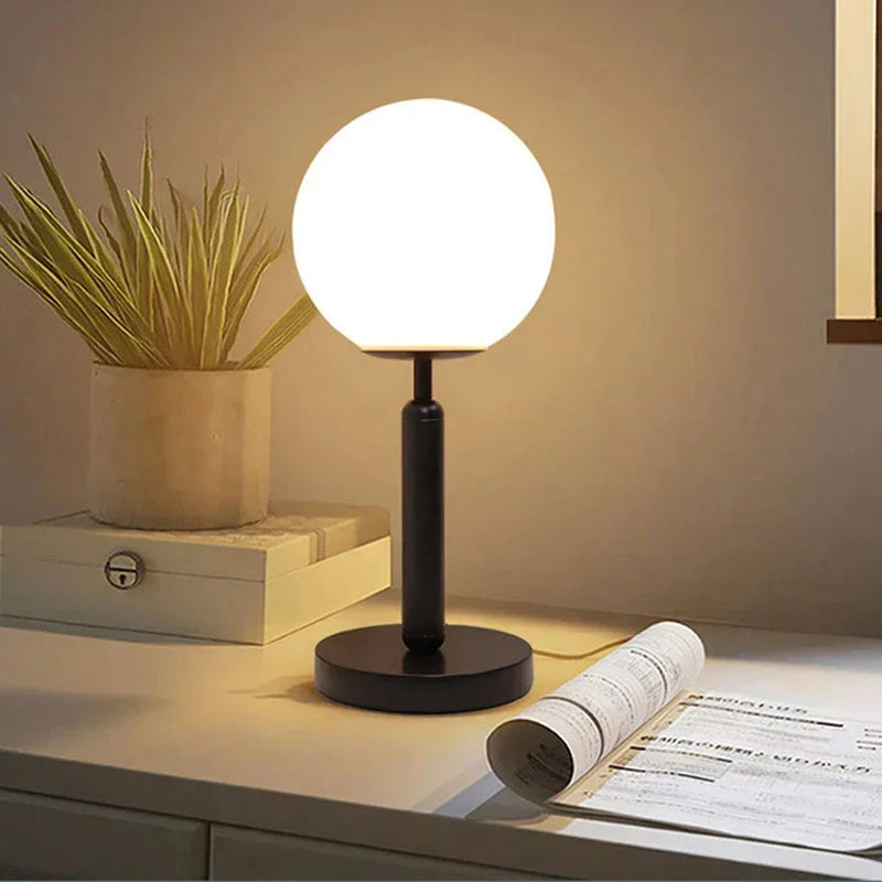 Black GlowSphere table lamp with glass ball LED light on a nightstand
