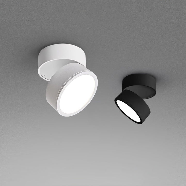 Black and white modern adjustable ceiling spotlights angled against a grey background