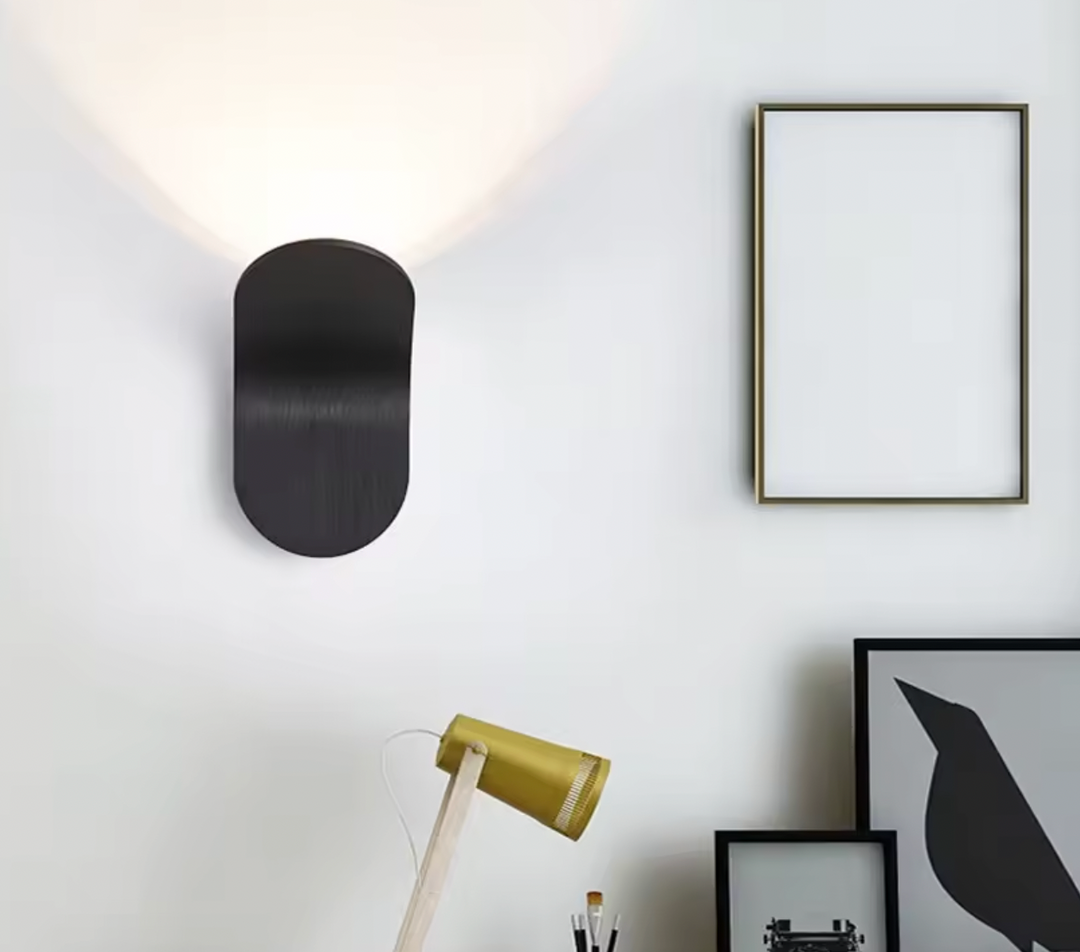 Curved white LED wall light fixture turned on in a room