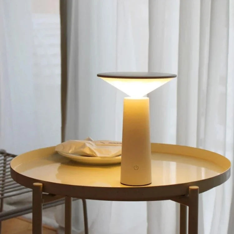 Modern white rechargeable table lamp on a round side table
