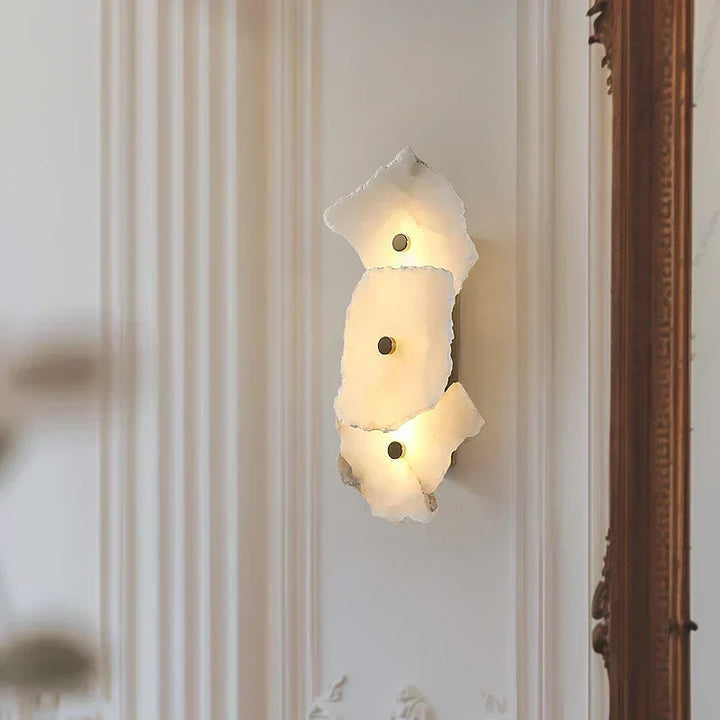 Modern textured alabaster wall light mounted on a decorated wall