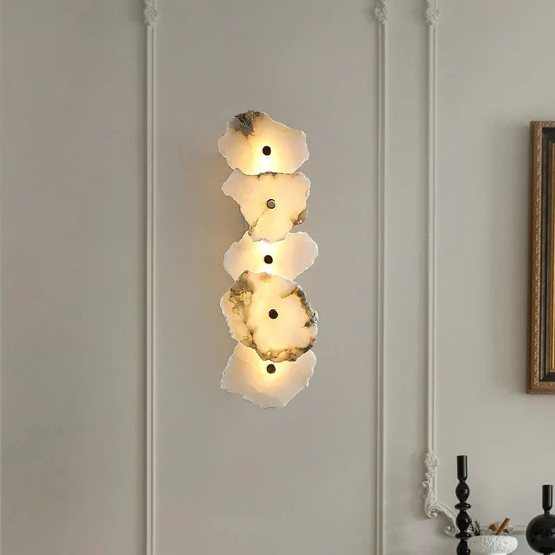 Full view of the layered natural veining wall sconce emitting a warm glow