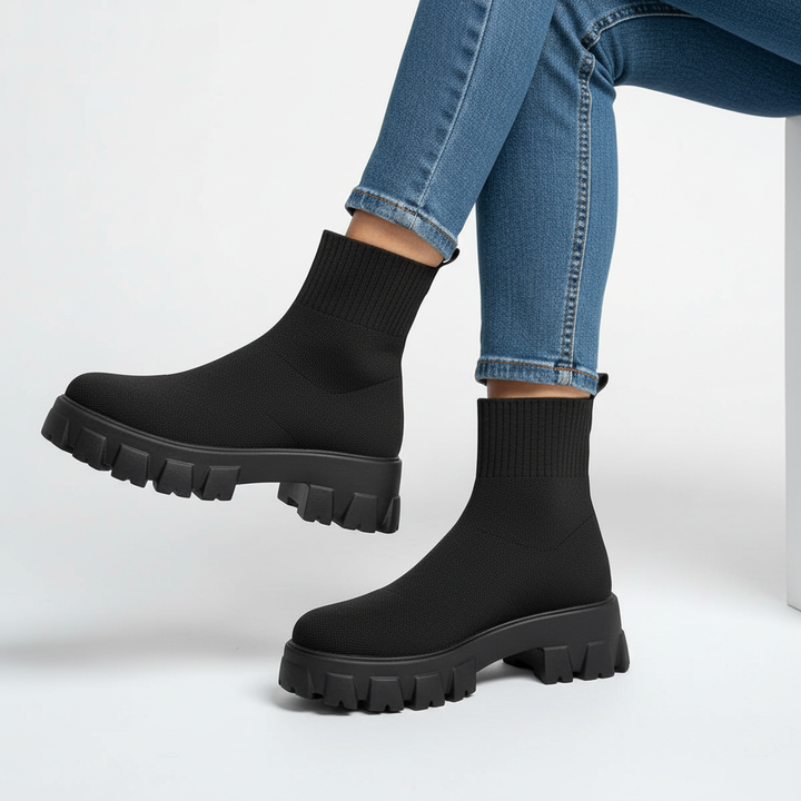 Close-up of stylish chunky heel on women's casual platform sock ankle boots in black
