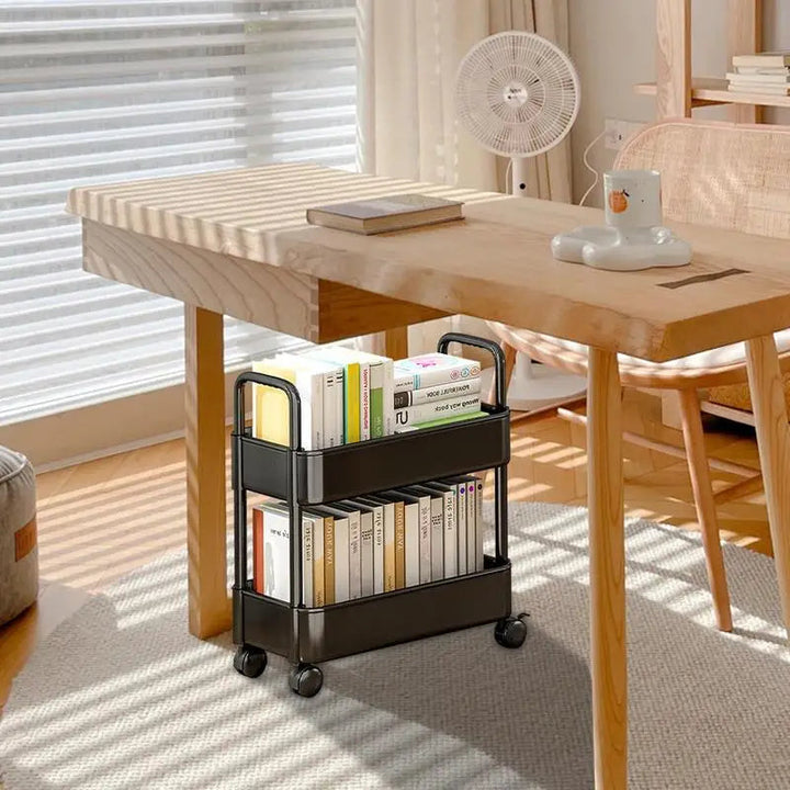Black rolling book cart positioned neatly beside a wooden desk