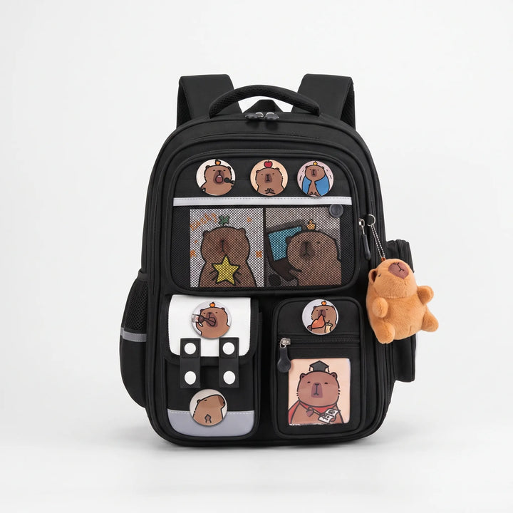 Front view of the black capybara school rucksack with plush toy and badges