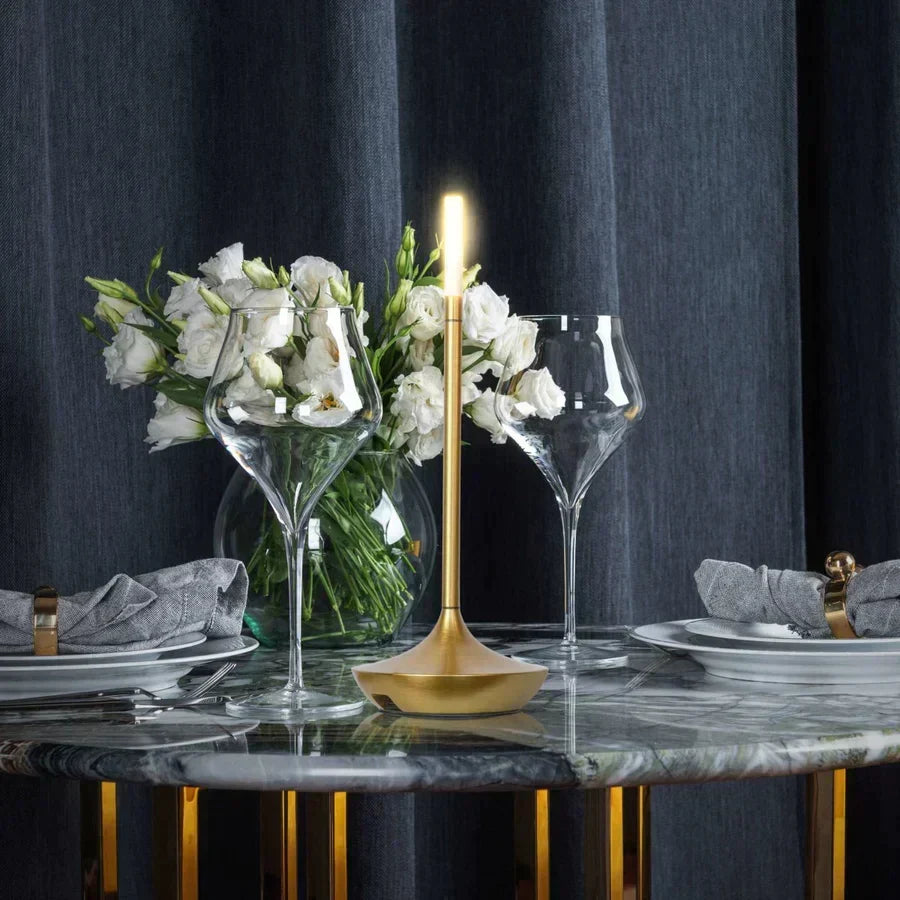 Gold cordless LED candle lamp on a beautifully set dining table