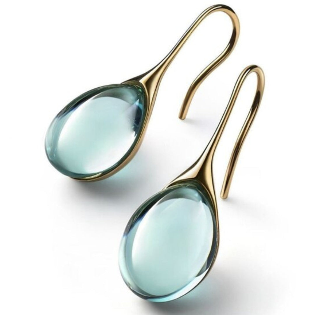 Light blue crystal drop earrings with polished gold hooks on white background