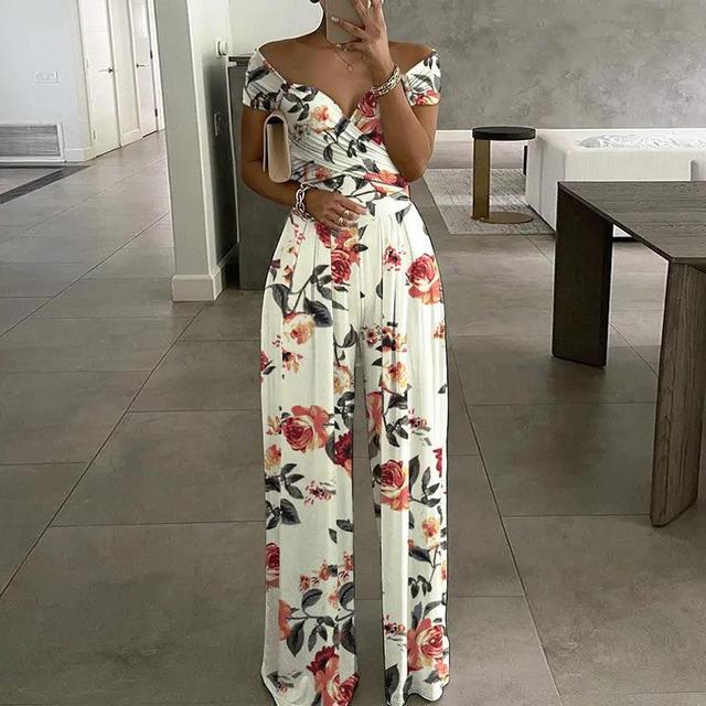 Woman wearing white floral off-shoulder wide-leg jumpsuit indoors