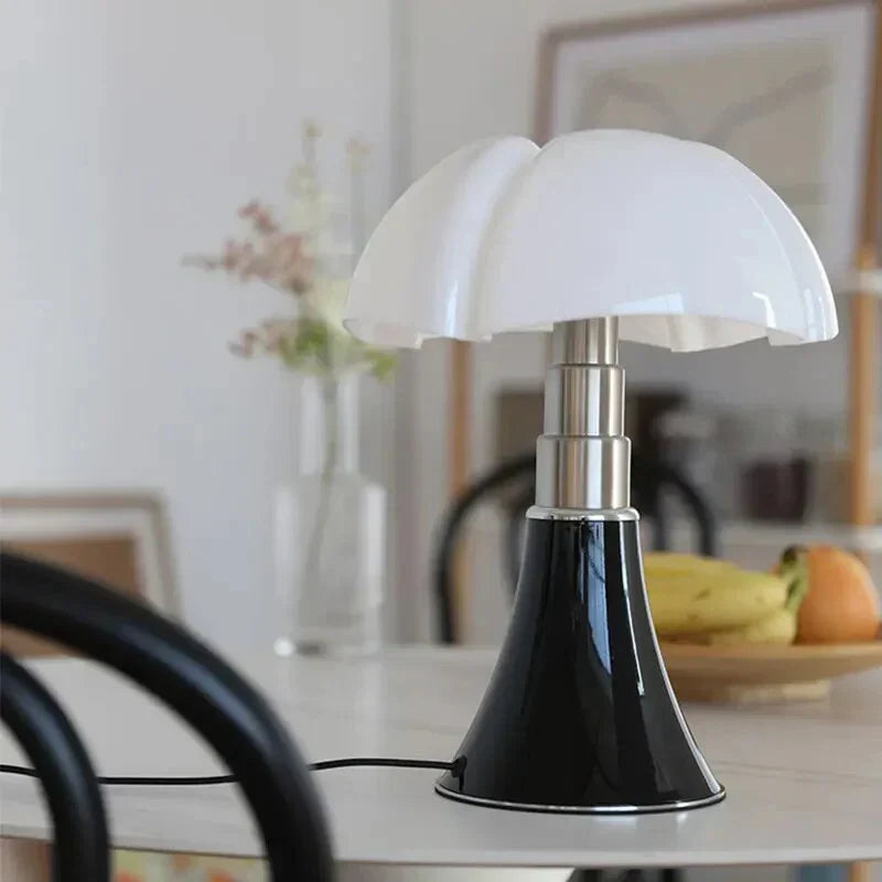 Black flower table lamp placed on a dining table with a blurred interior background