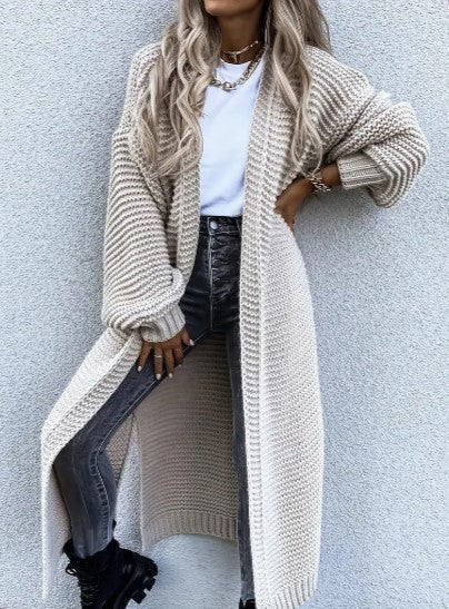 Woman wearing a beige long knit cardigan with ribbed cuffs and open front design