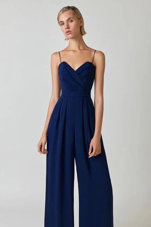 Model wearing a dark blue elegant wide leg jumpsuit with spaghetti straps