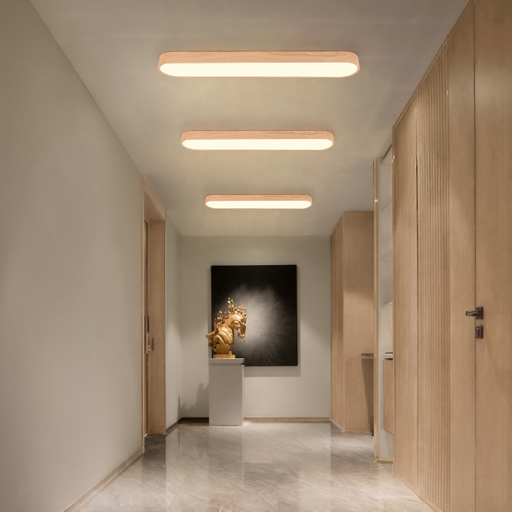 Multiple light brown Nordic oval LED ceiling lights installed in a hallway