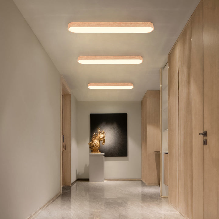 Multiple light brown Nordic oval LED ceiling lights installed in a hallway