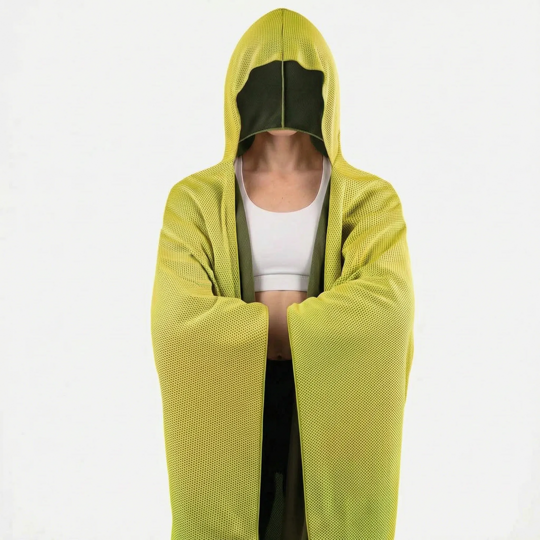 Person wearing blue hooded cooling towel drape at the beach during hot weather