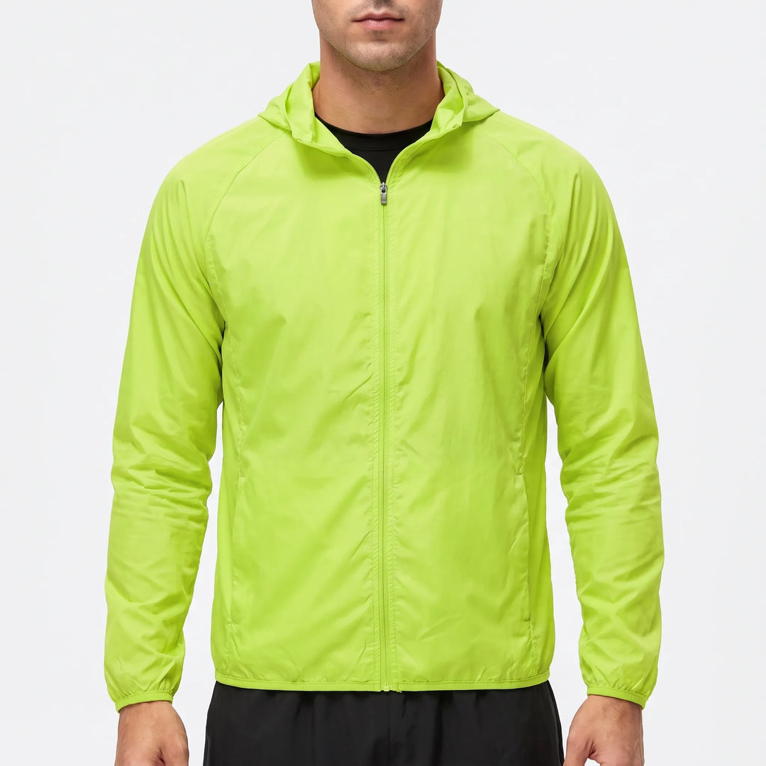 Man wearing a bright green lightweight hooded windbreaker against a white background