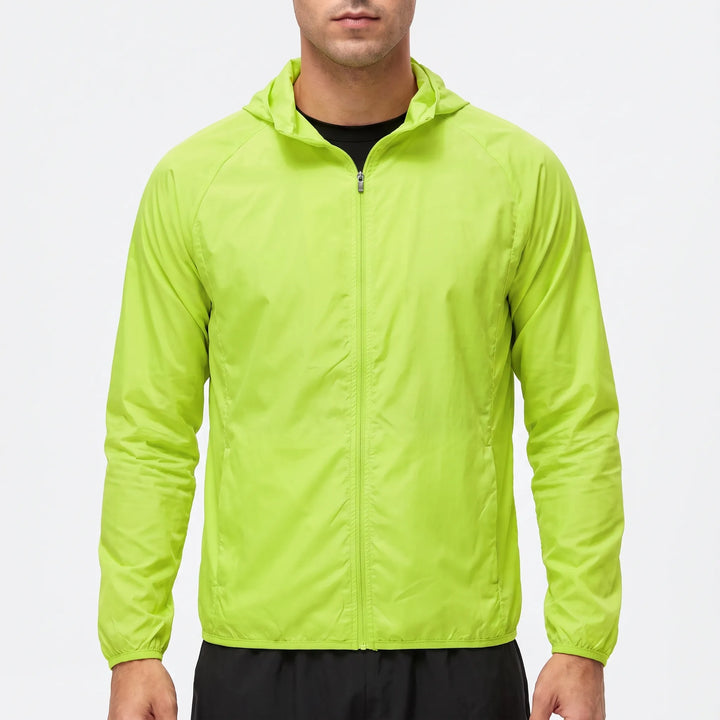 Man wearing a bright green lightweight hooded windbreaker against a white background
