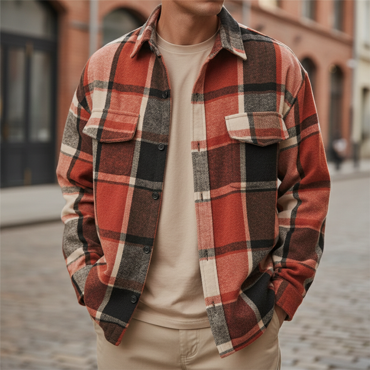 Model wearing an orange-red brushed plaid button-up shirt outdoors