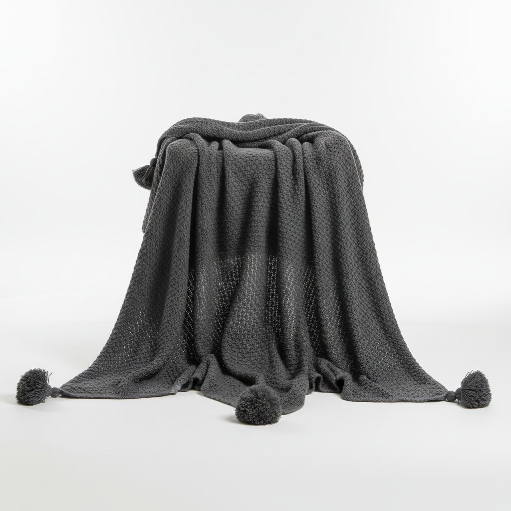 Soft knit blanket featuring a textured waffle pattern and stylish tassel fringe