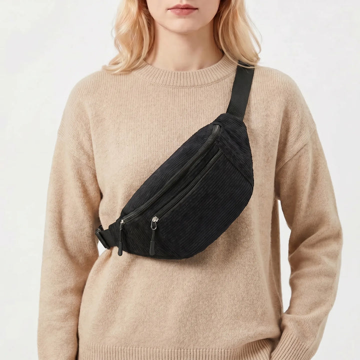 Model wearing a black ribbed crossbody bum bag with a neutral sweater