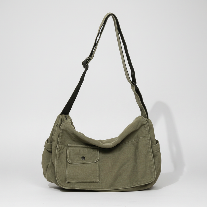 Flat lay of the versatile canvas messenger bag fully packed for daily travel.