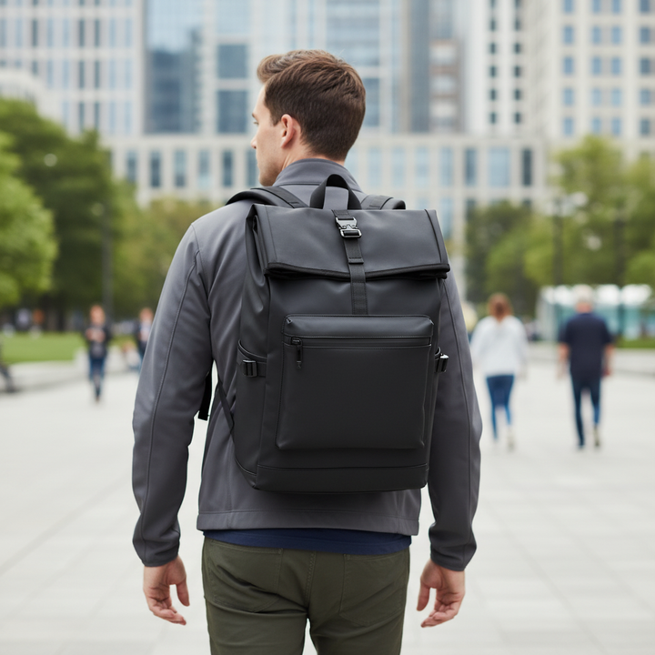 Man wearing a black minimalist roll-top commuter backpack outdoors in the city