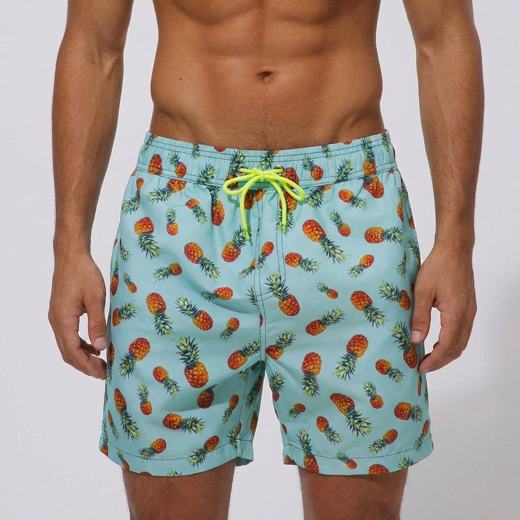 Close-up of men's light pineapple print board shorts with neon yellow drawcord