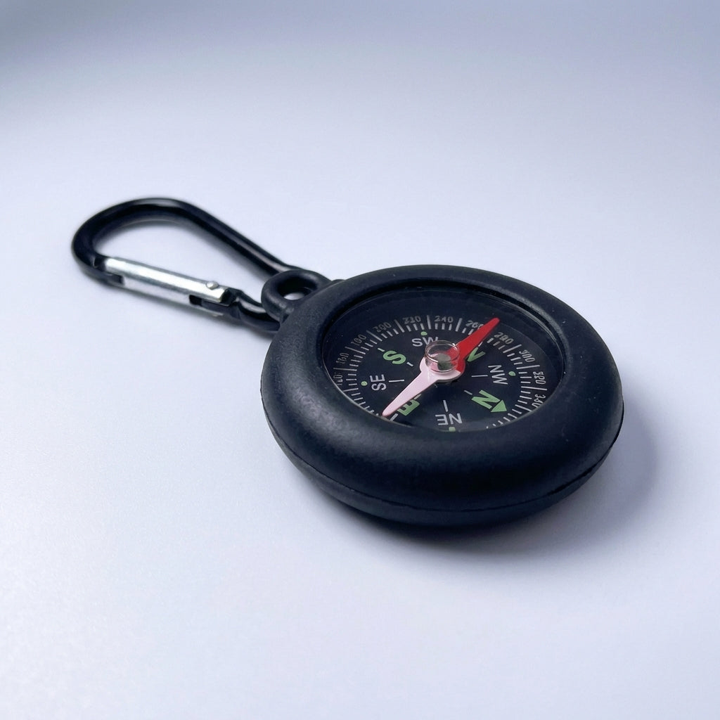 Essential camping gear compass hanging outdoors on a sunny hiking day