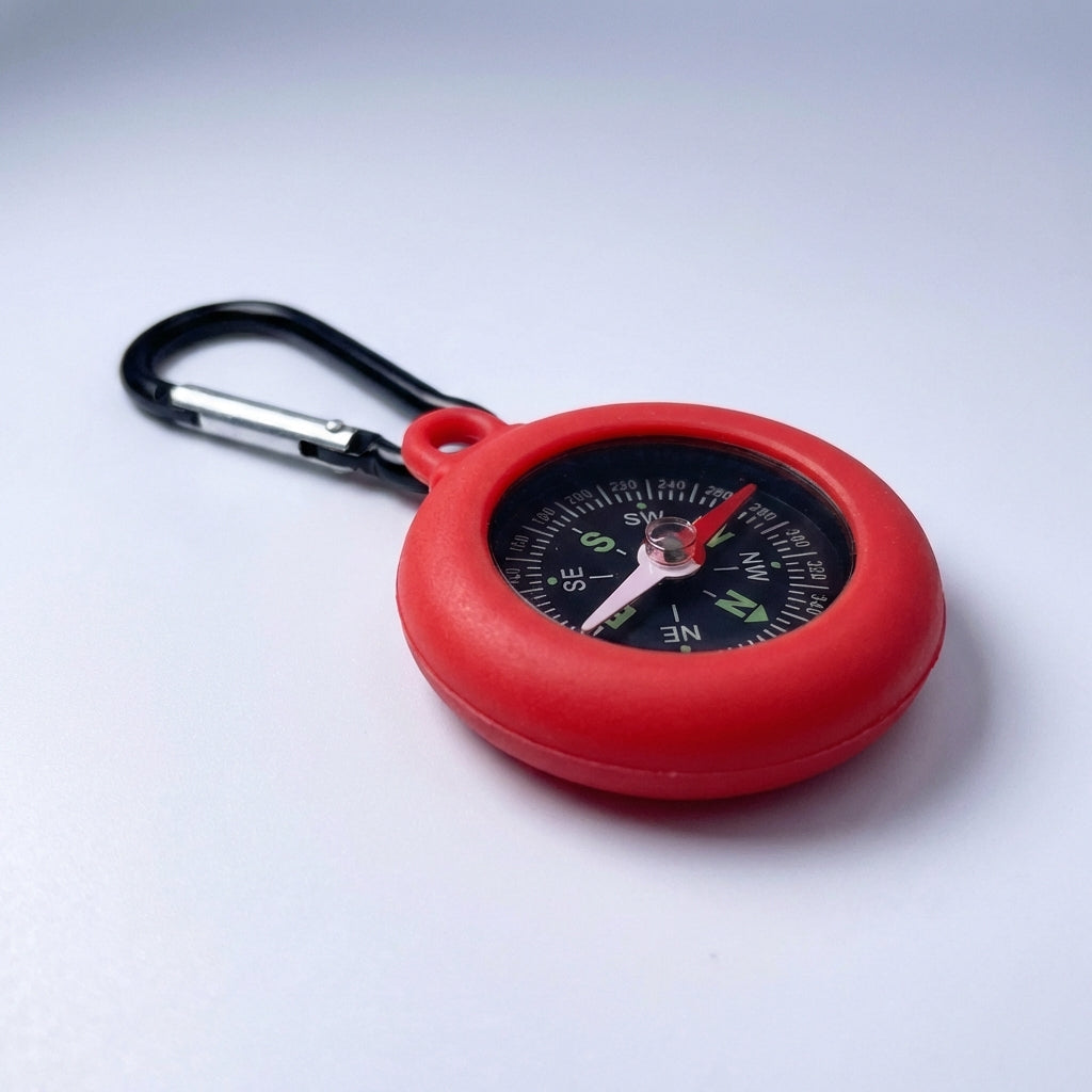 Close-up of a red compact carabiner compass on a white background