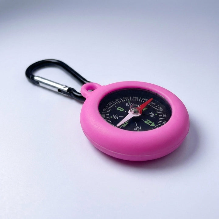 Lightweight survival compass accessory hanging from outdoor equipment strap