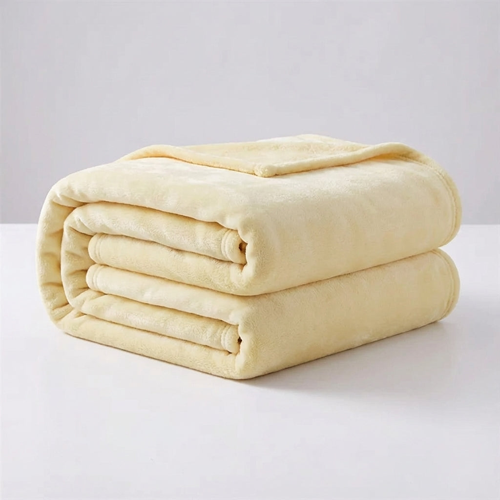 Snugluma bed throw blanket spread across an armchair in neutral tones