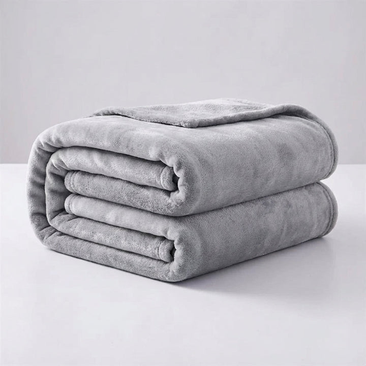 Snugluma travel blanket rolled up compactly with a ribbon tie