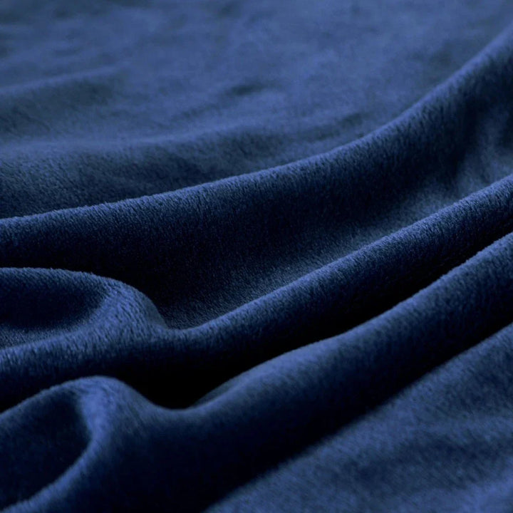 Snugluma lightweight bed throw blanket neatly arranged on a reading chair