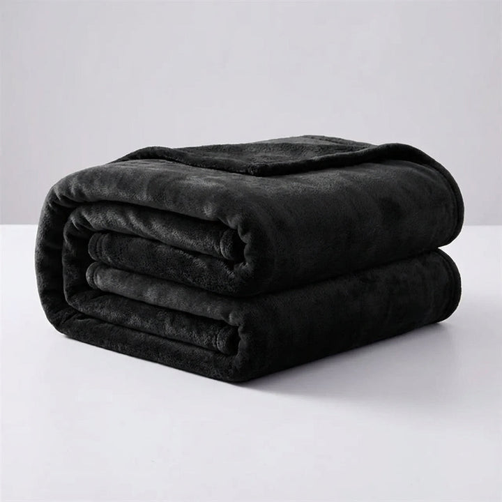 A neatly folded black plush throw blanket displayed against a clean light background.