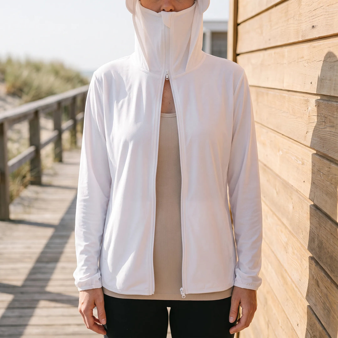 Model wearing white sun protection jacket with hood outdoors near wooden wall