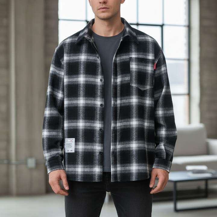 Man wearing black and white plaid long sleeve overshirt in industrial interior