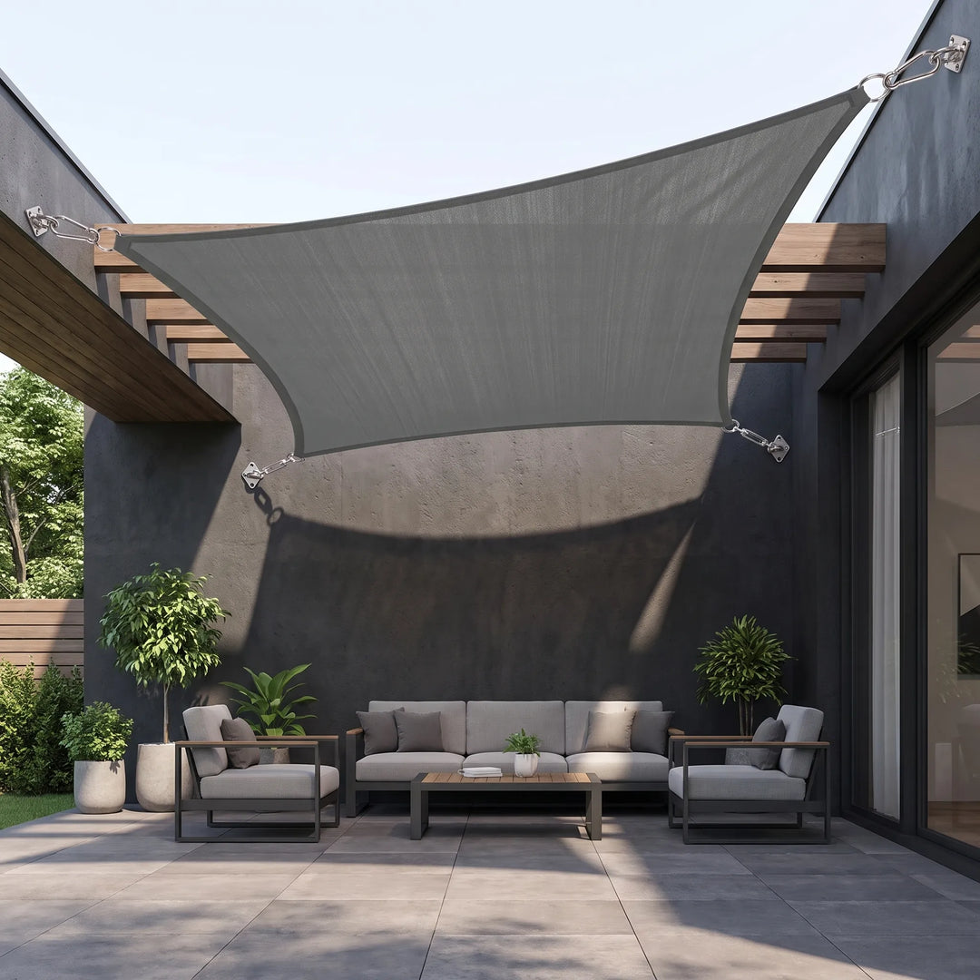 Dark grey triangular shade sail installed over an outdoor patio seating area