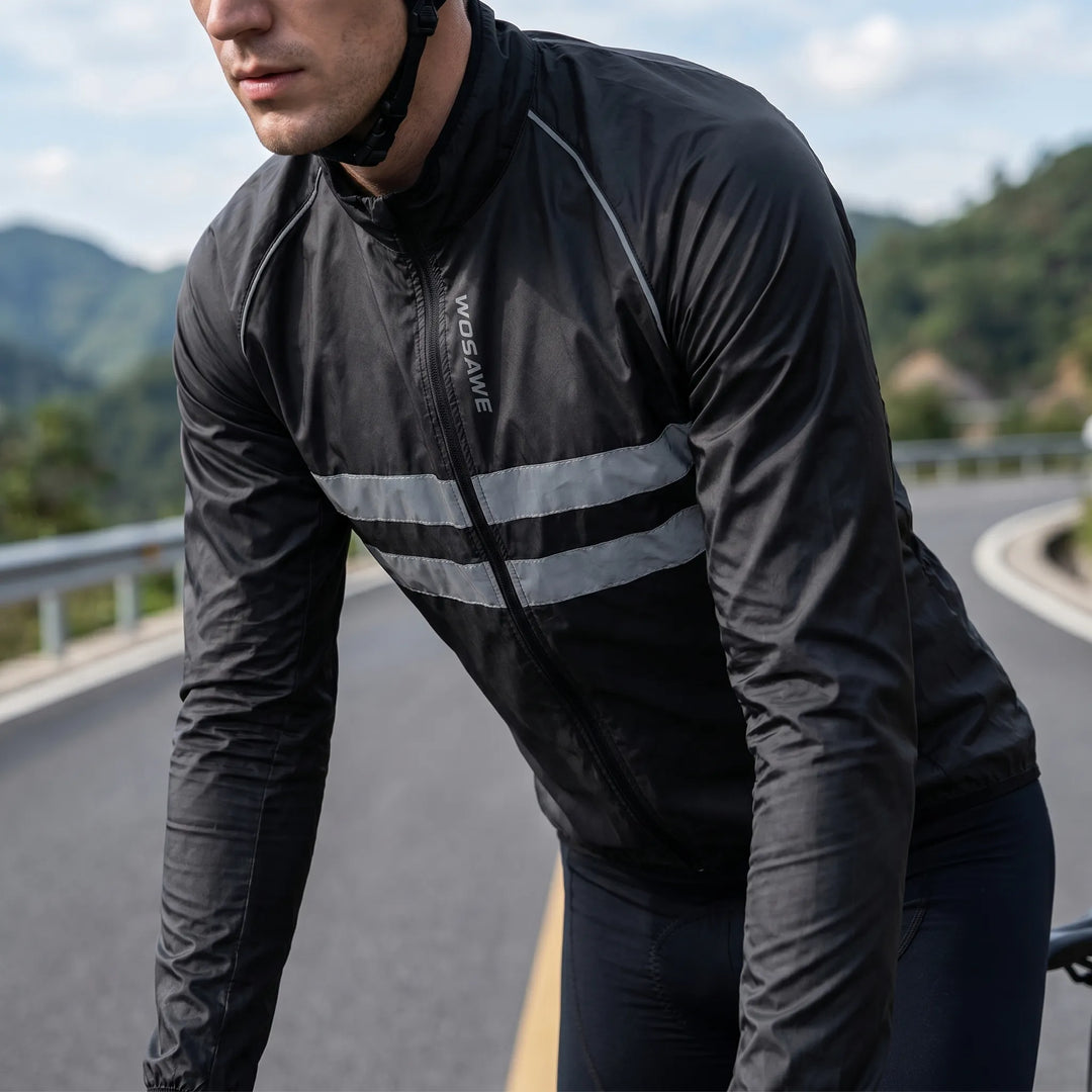 Man wearing a black cycling windbreaker jacket leaning over a bike
