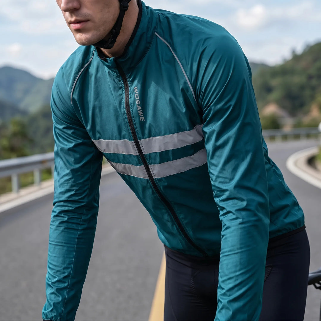 Man wearing a teal blue cycling windbreaker jacket outdoors