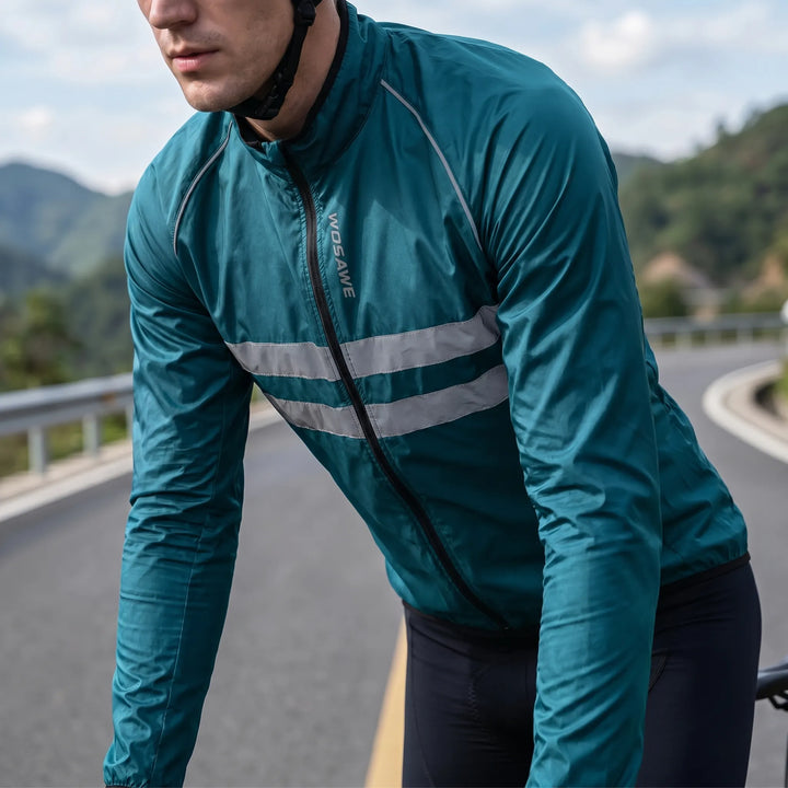 Man wearing a teal blue cycling windbreaker jacket outdoors