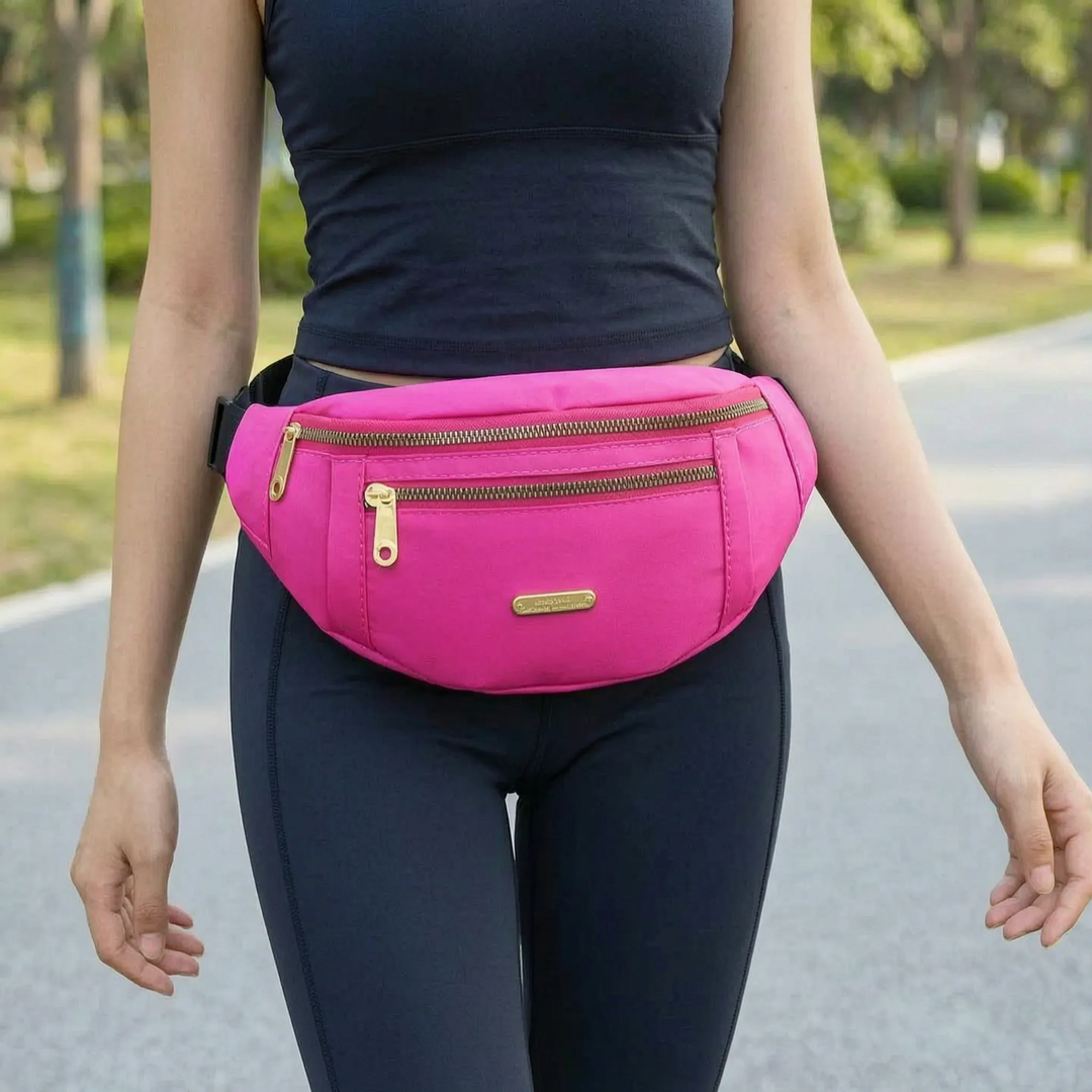 Woman wearing a bright pink multi-compartment waist pack across her waist outdoors