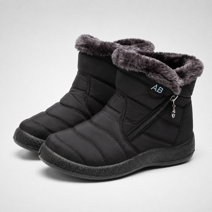 Pair of black winter ankle boots with plush faux fur trim on a neutral background