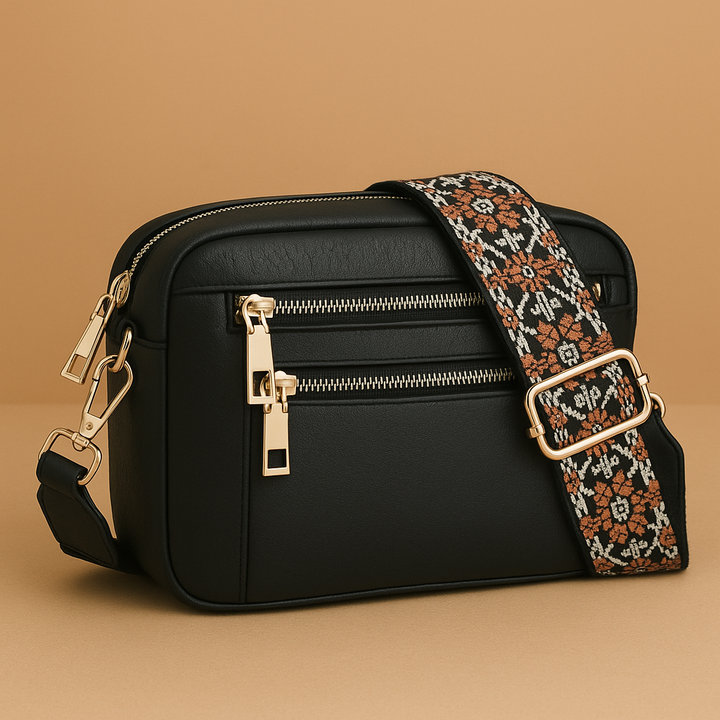 Black women's handbag with decorative patterned shoulder strap and gold hardware