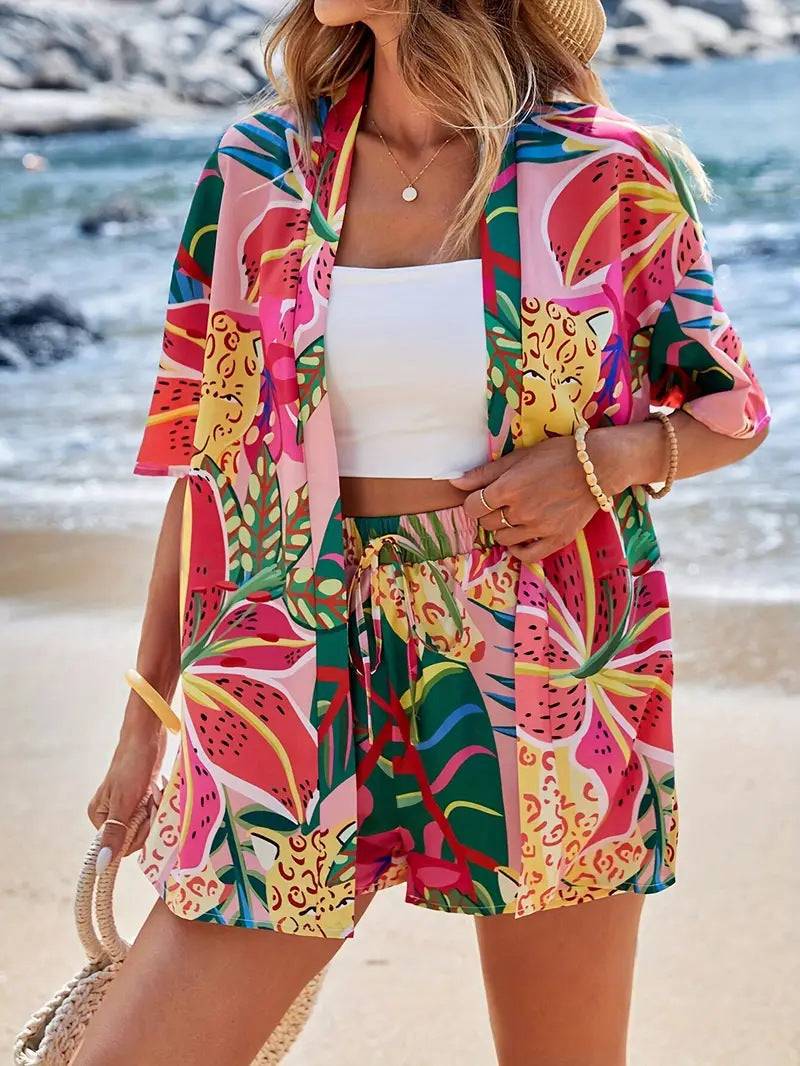 Woman wearing vibrant tropical printed kimono cardigan and high-waist shorts set at the beach