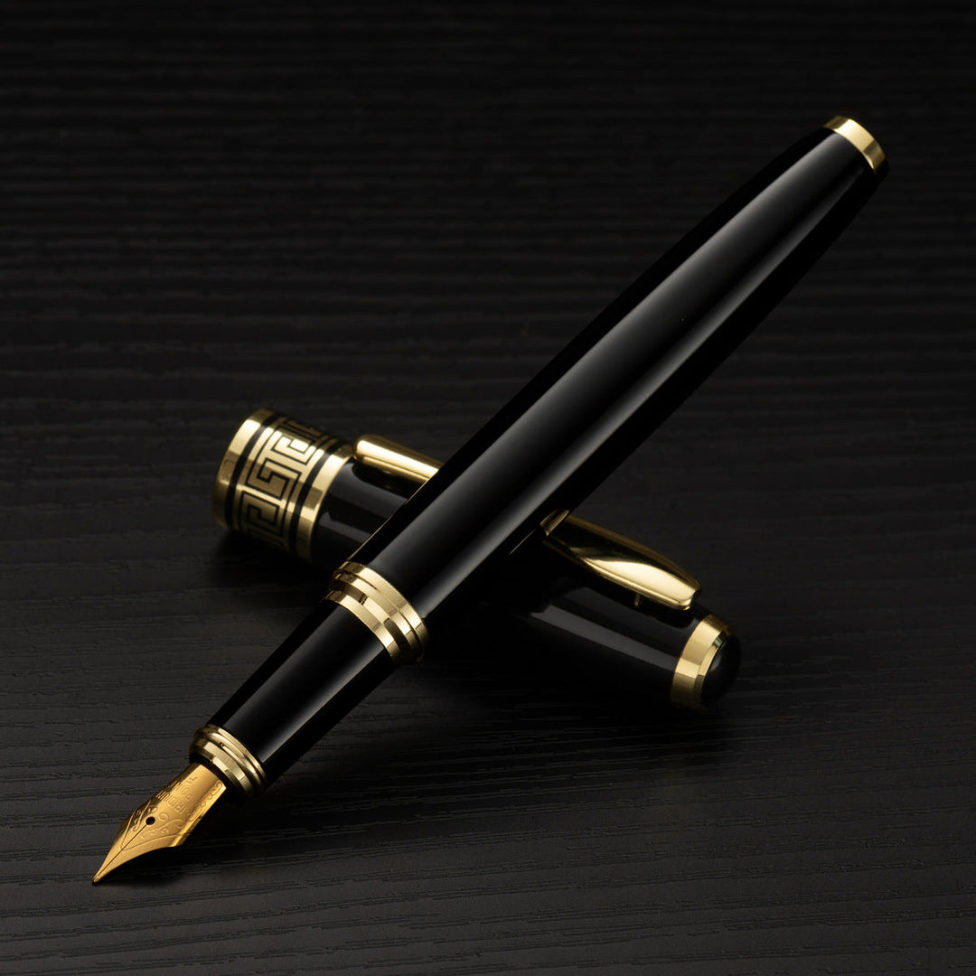 A sleek black fountain pen with gold accents displayed on a dark textured surface.