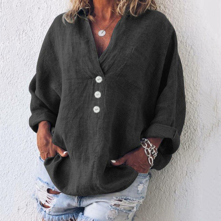Woman wearing a dark grey oversized v-neck long sleeve casual blouse
