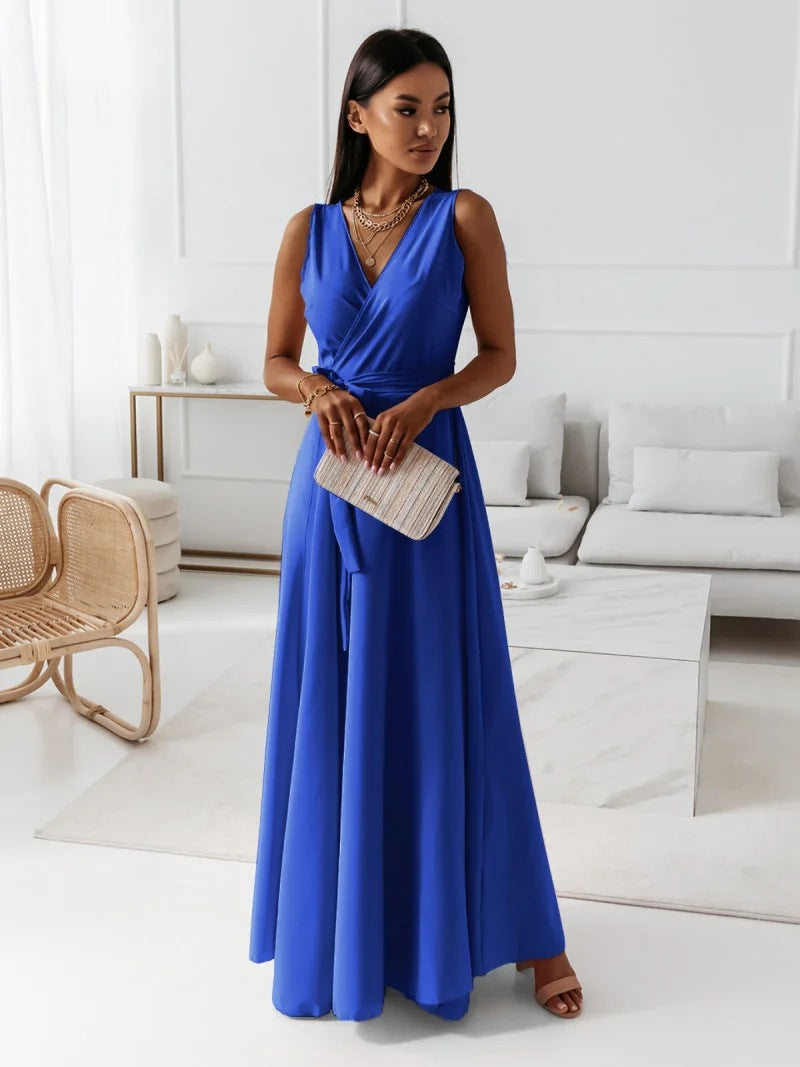 Woman wearing a vibrant blue sleeveless wrap maxi dress holding a clutch
