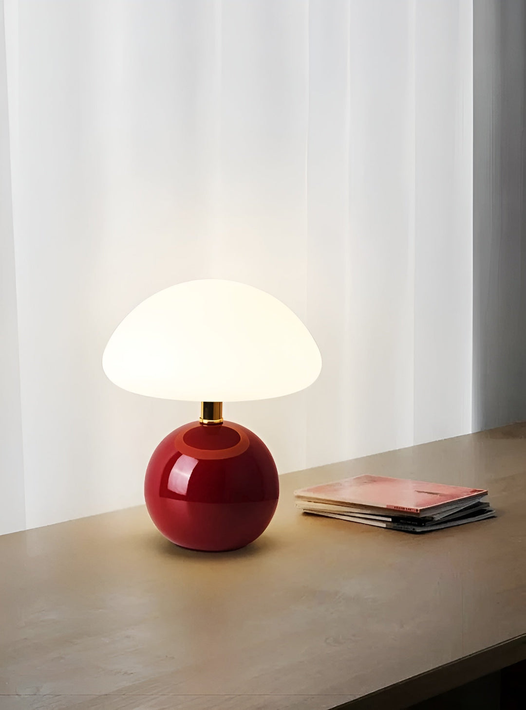 Burgundy mushroom LED table lamp resting on a wooden surface