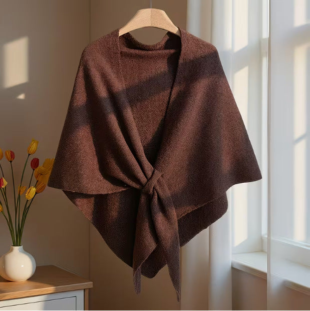 Coffee brown oversized knitted shawl draped and tied near a window with flowers