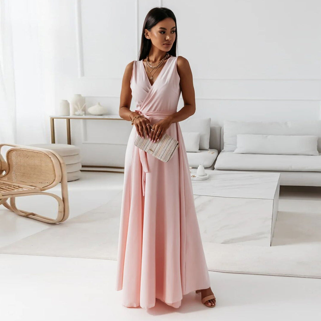 Woman standing elegantly in a light pink sleeveless formal maxi dress