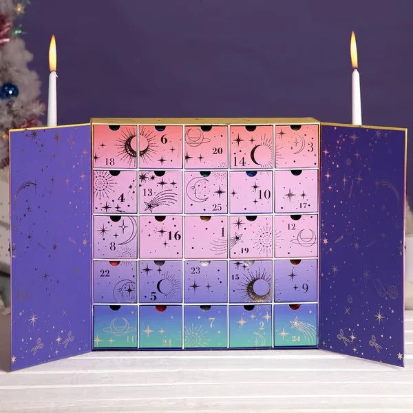 Celestial-themed crochet advent calendar box with 25 numbered drawers open against a purple backdrop.